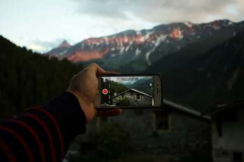 person taking digital image of mountain. Credit: Mael Balland via unsplash